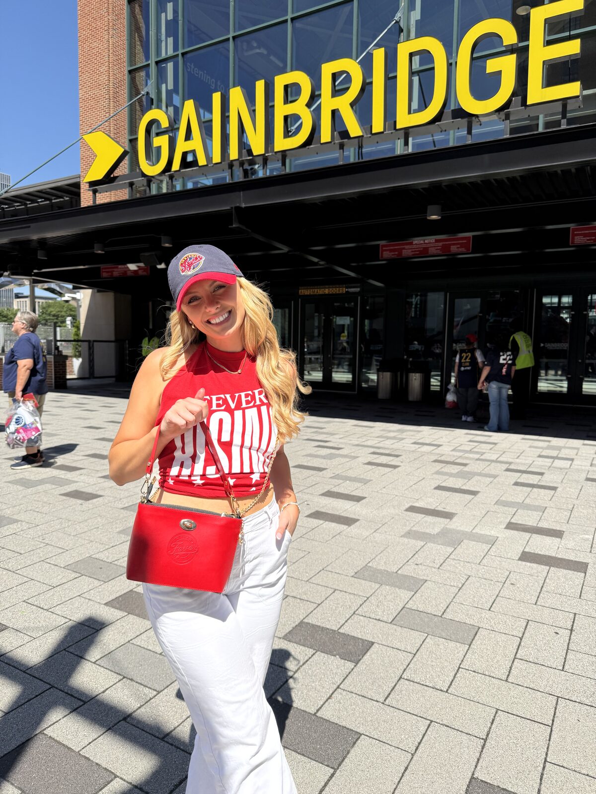 Fever fan wearing a red Caitie G bag at an arena