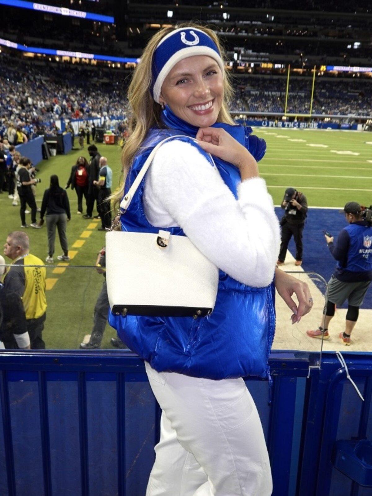 Football fan wearing a white Caitie G bag by the field